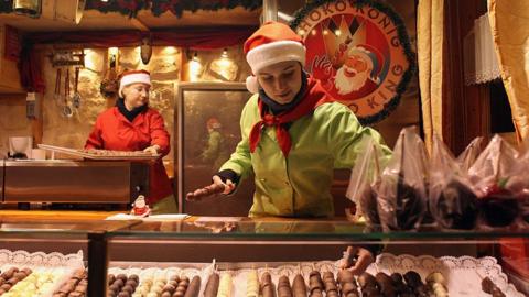 A chocolatier prepares her display at Birmingham's Frankfurt Christmas market