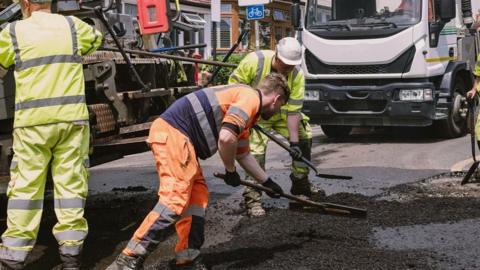 Generic photo of workers repairing a road