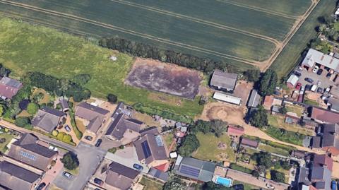 An aerial view of large piece of unused land where the flats would be built