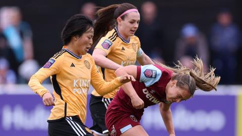 Emma Strom Snerle of West Ham United is challenged by Sam Tierney and Saori Takarada of Leicester City