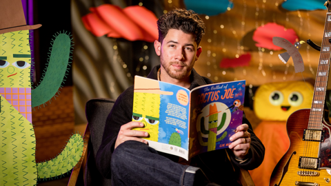 Nick Jonas with a book foreground