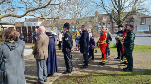 People standing for a minute's silence at Memorial Corner in Dorchester on Sunday.