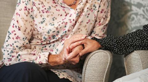 Care home resident holding hands