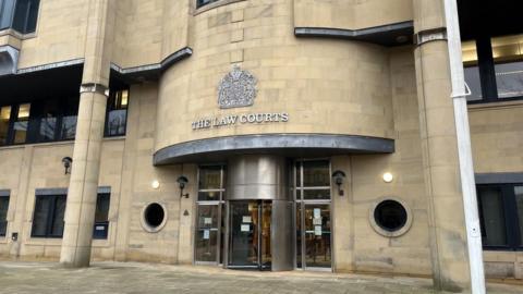 Stock image of the entrance to Bradford Crown Court, with The Law Courts above a revolving door.