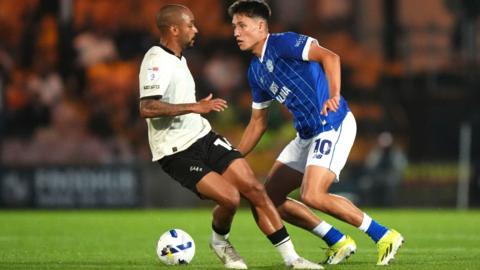 Llun o Rubin Colwill yn wynebu chwaraewr Port Vale