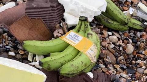 A bunch of bananas washed up on a pebbled beach