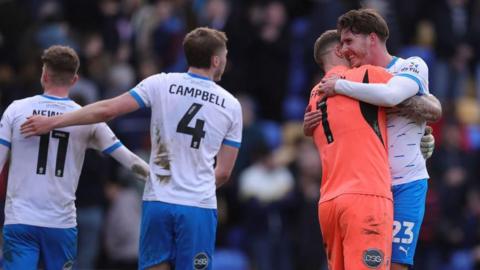 Barrow players hug each other at the final whistle after their 2-2 draw with AFC Wimbledon