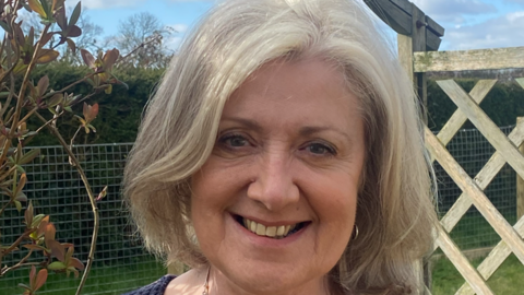 A headshot of a woman smiling straight into the camera. 