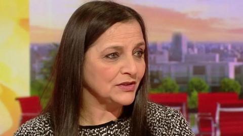 Campaigner Figen Murray with long black hair and green eyes wearing a dog-tooth patterned jumper speaking on BBC Breakfast  