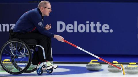 GB wheelchair curling skip Hugh Nibloe shows his team where to aim for on the ice
