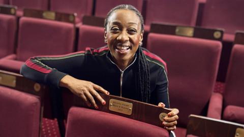 Singer Beverley Knight smiling broadly in a theatre stalls, with red seats. Her hand is next to a gold plaque with her name on it stating Beverley Knight, Marie & Rosetta, 2025.