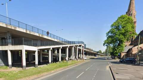 Selby Street pictured along the section which runs next to a raised section of Anlaby Road.  There is a pedestrian bridge running beneath the road.