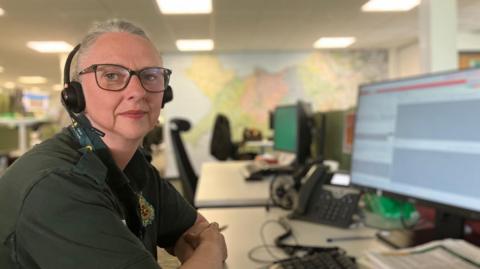 Kate, yng nghanolfan alwadau'r gwasanaeth ambiwlans yn Llanelwy