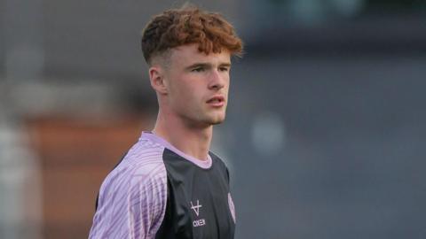 Tommy McDermott in action warming up for Shrewsbury Town