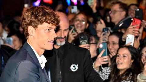 Jannik Sinner signs autographs as he arrives at the ATP Finals in Turin