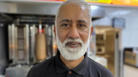 Ifty Ahmed standing in his chip shop