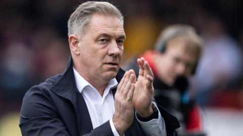 Scott Lindsey applauds the Crawley Town fans after a League Two match