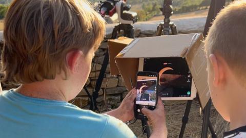 Boys looking at image of eclipse