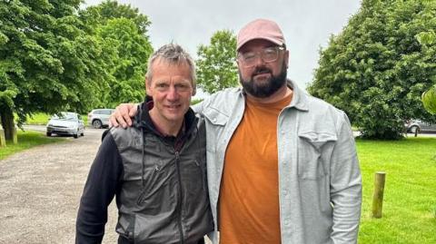 Stuart Pearce with short hair standing next to Maddox Jones with dark hair and beard