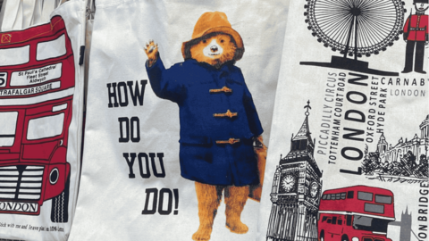 A fake tote bag with Paddington bear waving with words on the left saying 'how do you do!'