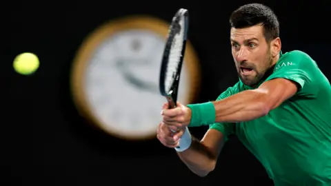 Novak Djokovic watches the ball