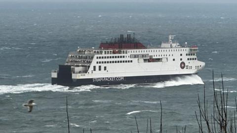 The Manxman ferry, which is white, black and red, sailing in choppy seas in Douglas Bay.