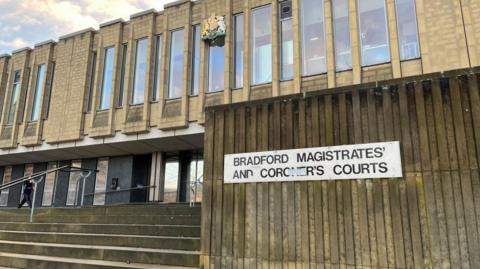 Bradford Magistrates' and Coroner's Courts: a yellow stone building with steps leading to glass doors