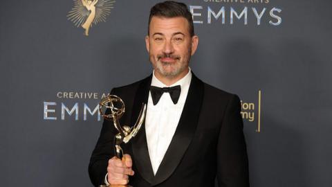 Jimmy Kimmel holds an award at the Emmys