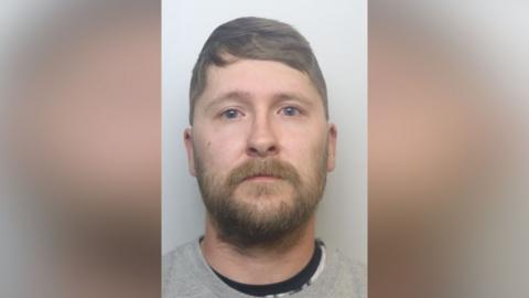 Mugshot of Crowther. he has a short thick brown beard and short light brown hair swept over his head.