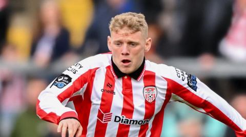 Josh Thomas playing for Derry City in a red-and-white striped kit