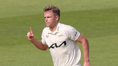 Sam Curran with his finger in the air after taking a wicket for Surrey