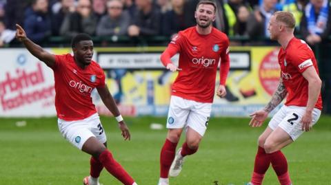 Beryly Lubala has his arm aloft after opening the scoring for Wycombe at Wealdstone