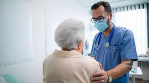 A doctor wearing a mask with a patient 