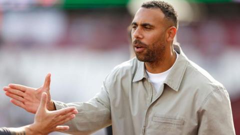 Anton Ferdinand shaking hands with a person off camera