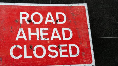 A close-up picture of a red road ahead closed sign