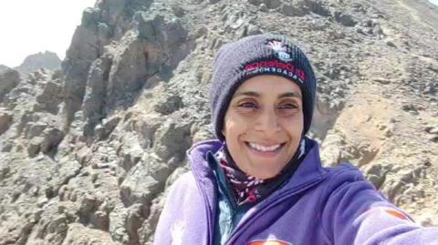 Zaynab Jogi, smiling at the summit of Mount Toubkal