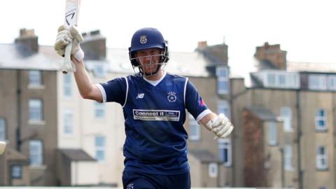 Liam Dawson raises his bat to acknowledge applause from the crowd at the end of his innings against Yorkshire in Scarborough