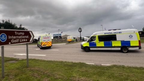 Three police vans passing a roundabout near the Trump International Golf Links in Ayrshire.
