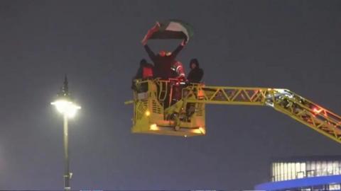 Man being taken down from tower