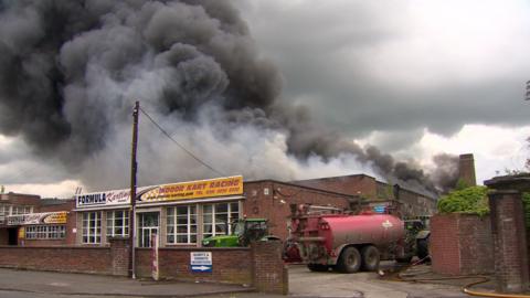 The scene as plumes of smoke rise from the building