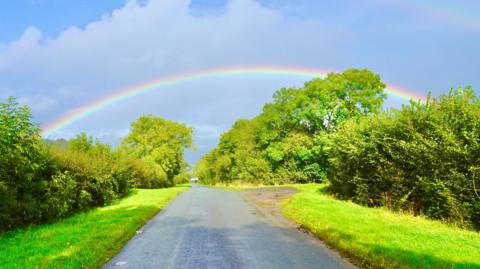 A rainbow over a rural road