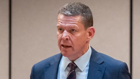 A man, Rhun ap Iorwerth, is in a navy suit.