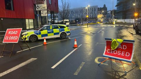 Road closed signs and a police car in Plymouth