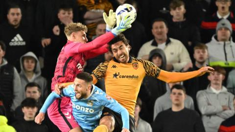 Coventry keeper Carl Rushworth leaps to collect a cross