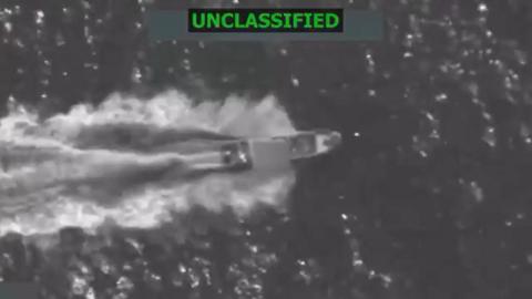 A boat moments before it is blown out of the water