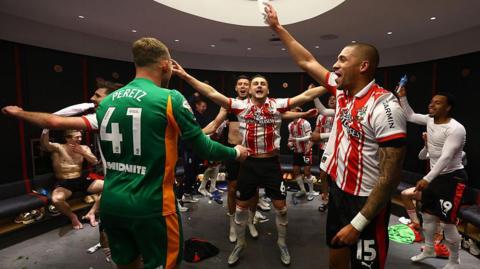 Taylor Harwood-Bellis and his Southampton teammates celebrate in the dressing room after the Championship play-off semi-final win over Middlesbrough 