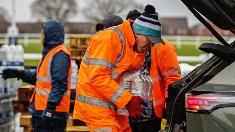 Man holding bottled water.