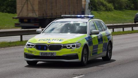 A police car travelling on a main road