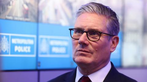 Prime Minister Sir Keir Starmer during his visit to a police station in Lambeth, south London. Picture date: Friday May 15, 2026. He is wearing a dark suit and light shirt and is against the backdrop of a Metropolitan Police sign.