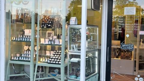 The storefront of Estcourt Jewellers. There are large windows showing displays of rings, necklaces, bracelets and earrings.